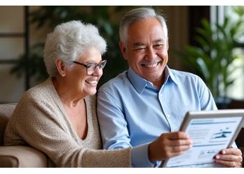 Two Singaporean seniors happily reviewing financial documents on a tablet, symbolizing a secure retirement.